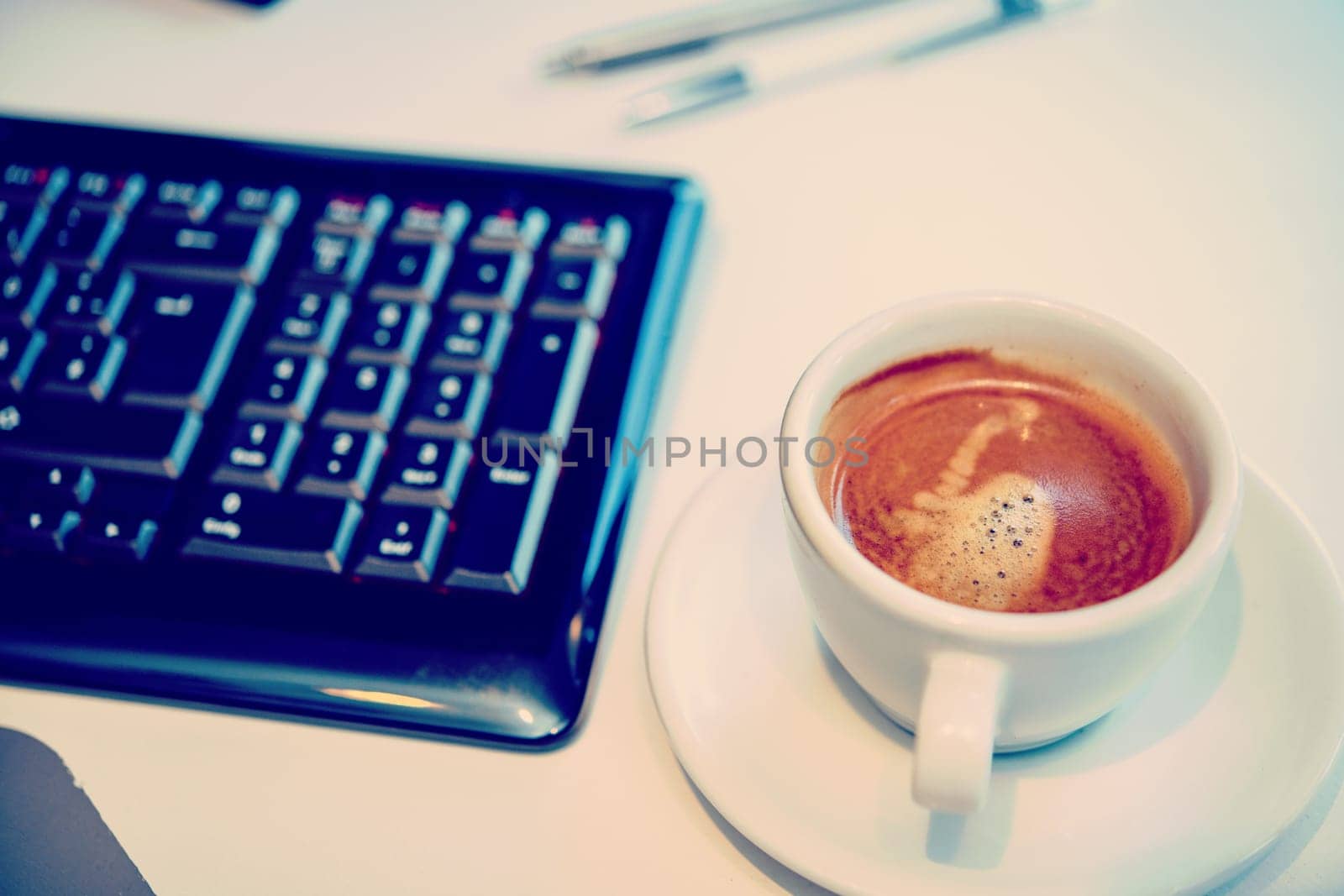 cup with coffee on tesk with computer keyboard