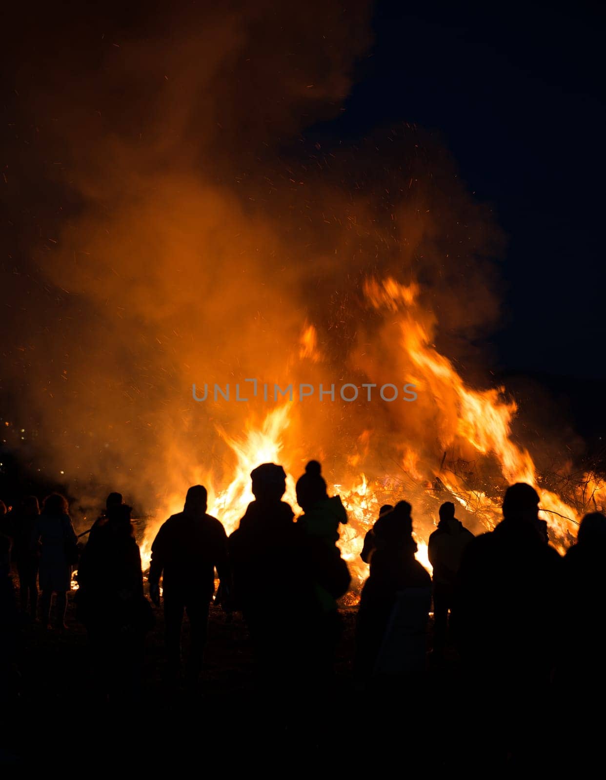silhouettes of people in frontof big easter fire