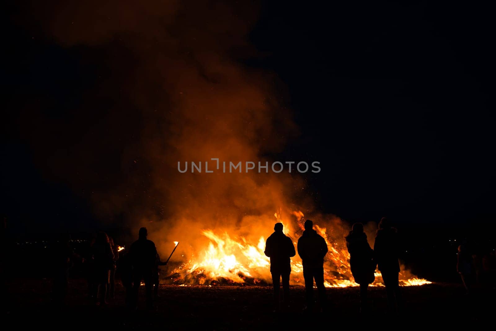 silhouettes of people in frontof big easter fire