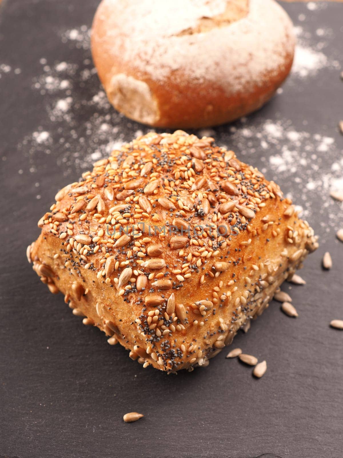 Tasty organic rolls on a dark slate cutting board, natural healthy eating