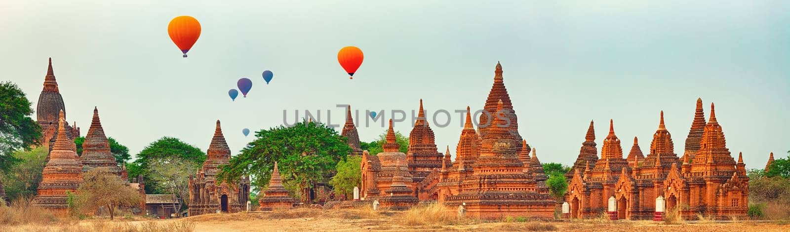 Balloons over Temples at sunrise in Bagan. Myanmar. Panorama