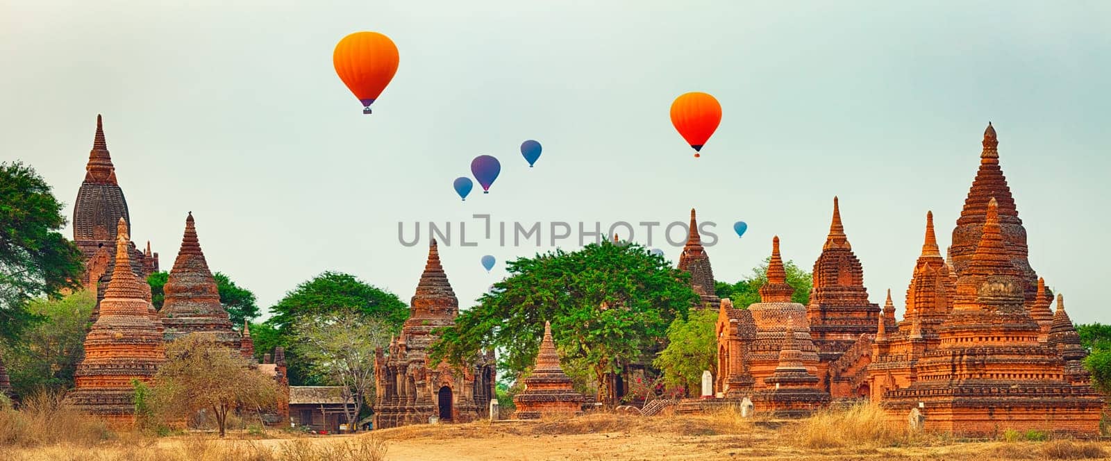 Balloons over Temples at sunrise in Bagan. Myanmar. Panorama