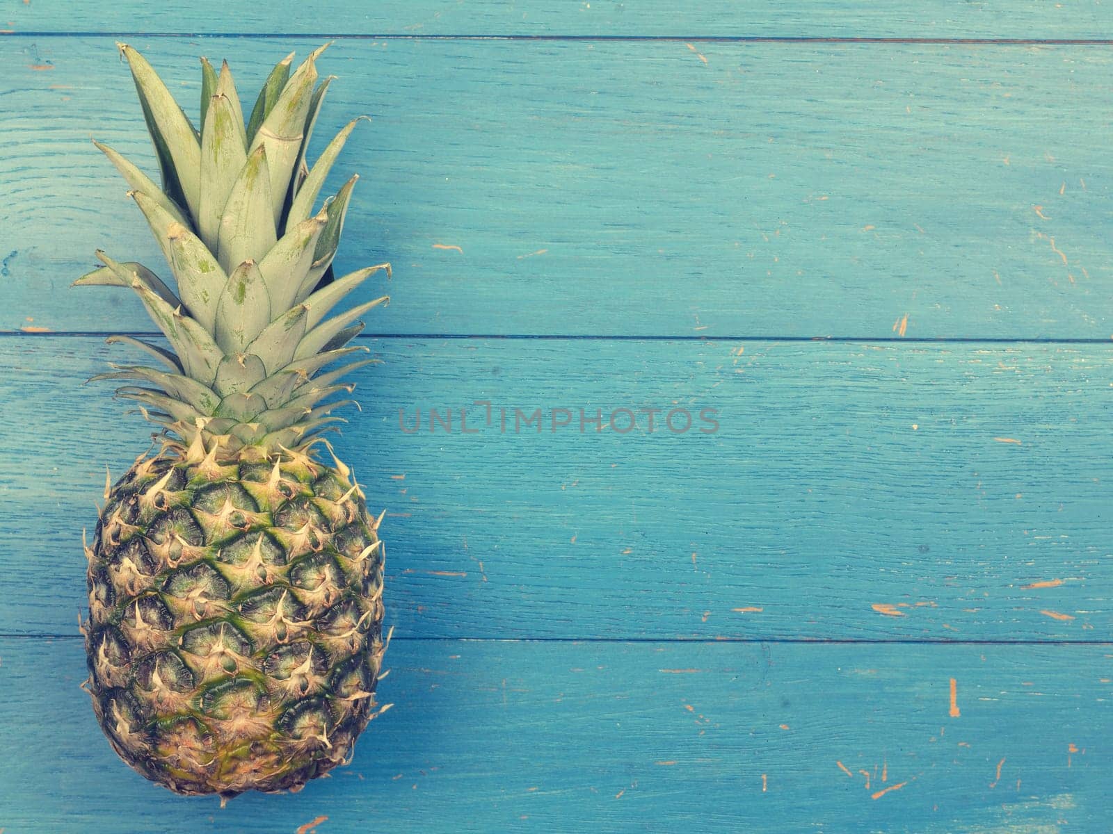 Sweet organic pineapple on a blue rustic wooden background