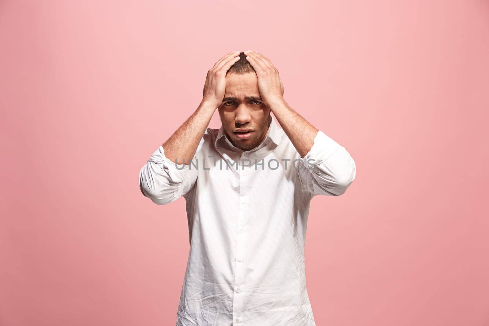 Horrible, stress, shock. Male half-length portrait isolated at pink studio. Young emotional surprised afro man clasping head in hands. Human emotions, facial expression concept. Trendy colors. Front view