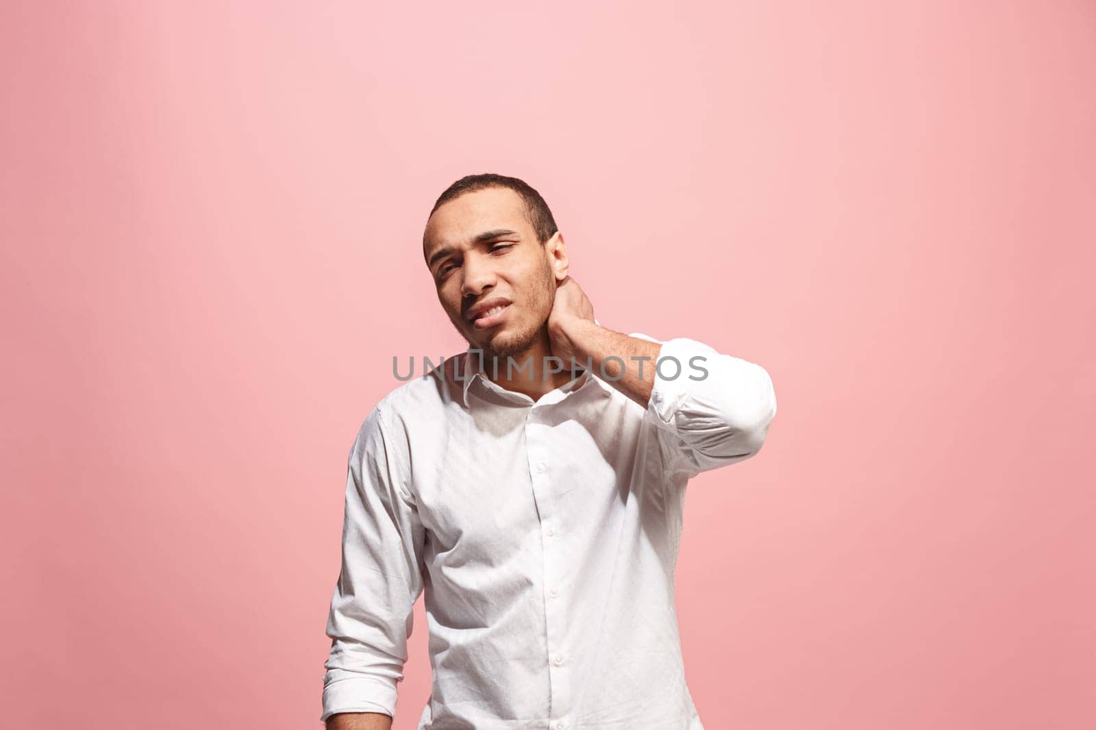 Pain concept. Beautiful male portrait isolated on pink backgroud. Young emotional surprised afro man looking at camera.Human emotions, facial expression concept. man overwhelmed with pain in neck
