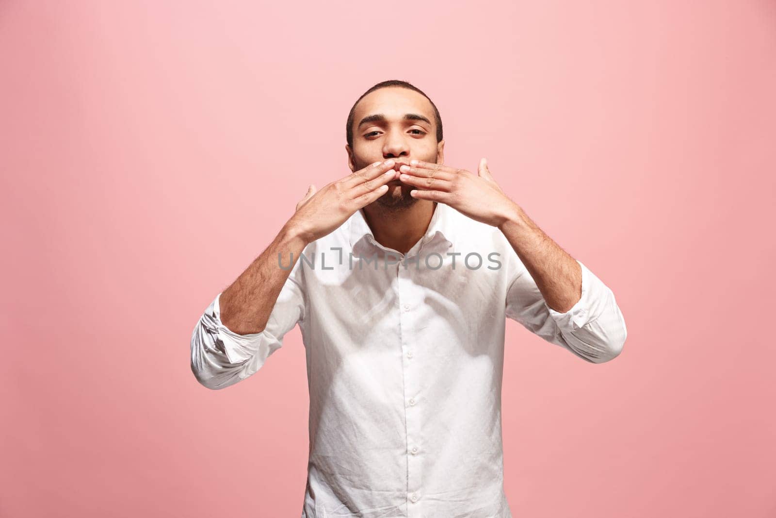 I kiss you. Portrait of attractive afro man with kiss on lips. Pink studio. Beautiful male portrait. Young happy emotional funny man looking at camera. Human facial emotions concept. Trendy colors
