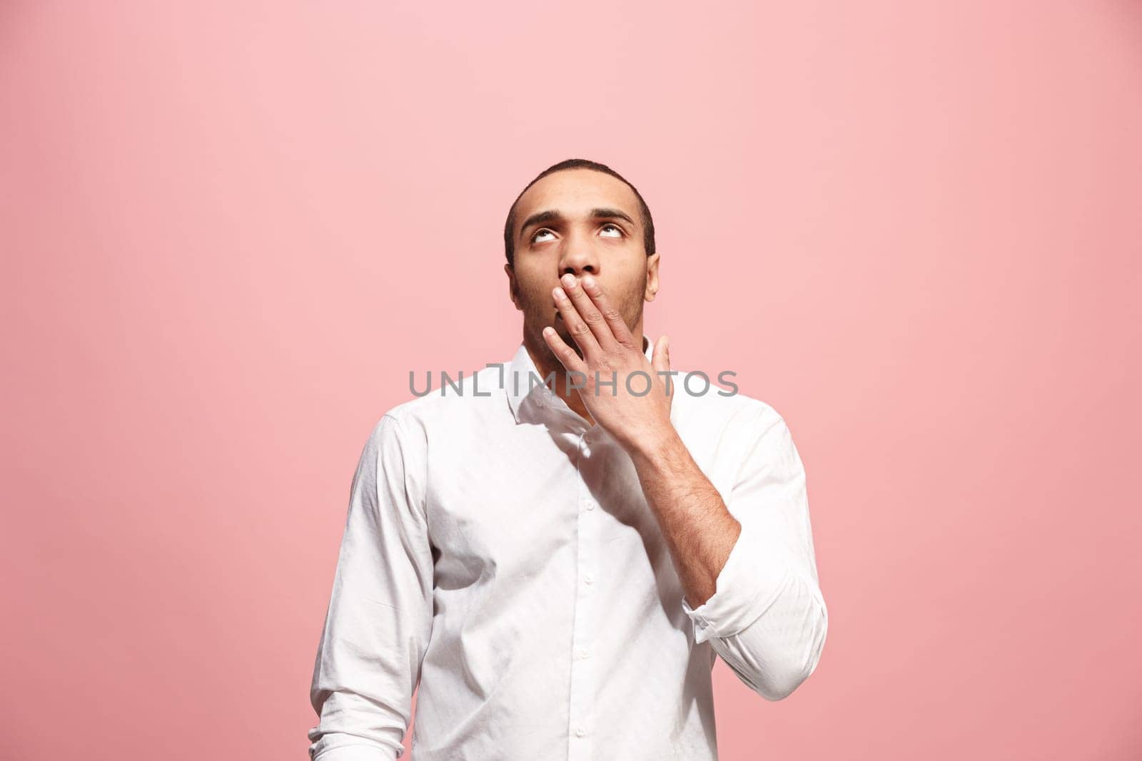 I am tired of everything. Bored man. Boring, dull, tedious concept. Young caucasian emotional afro man. Human emotions, facial expression concept. Studio shot isolated on trendy pink background
