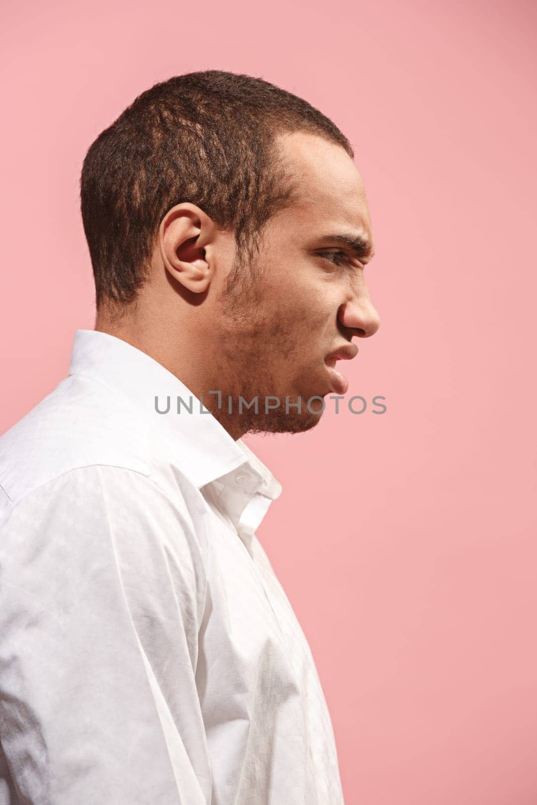 Screaming, hate, rage. Crying emotional angry afro man screaming on pink studio background. Emotional, young face. male half-length portrait. Human emotions, facial expression concept. Trendy colors. . Profile