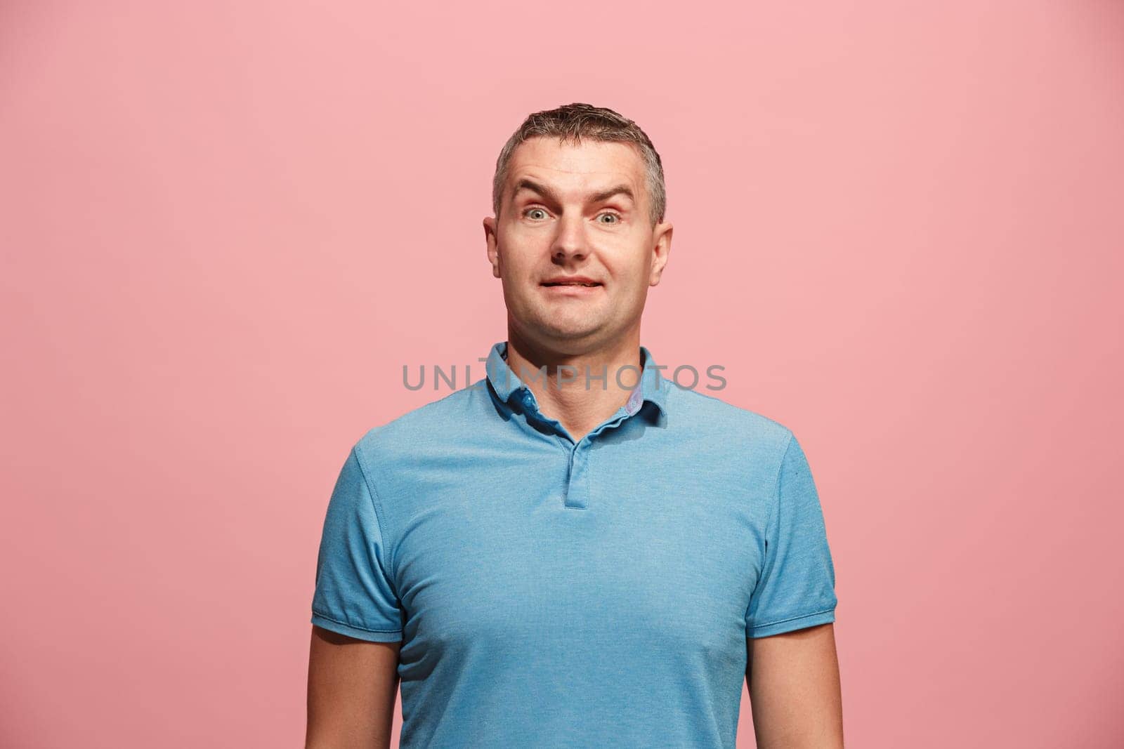 Wow. Attractive male half-length front portrait on pink studio backgroud. Young emotional surprised bearded man standing with open mouth. Human emotions, facial expression concept. Trendy colors