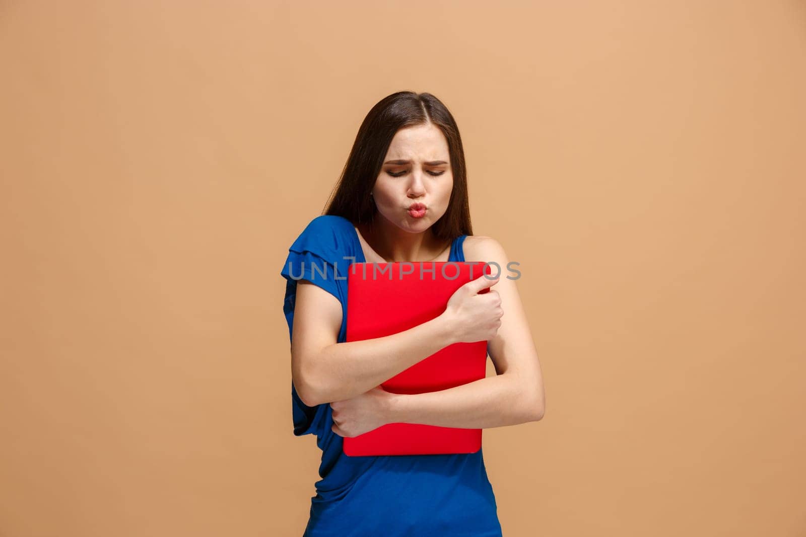 Businesswoman hugging laptop. Love to computer concept. Attractive female half-length front portrait, trendy pastel studio backgroud. Young emotional pretty woman. Human emotions, facial expression concept.