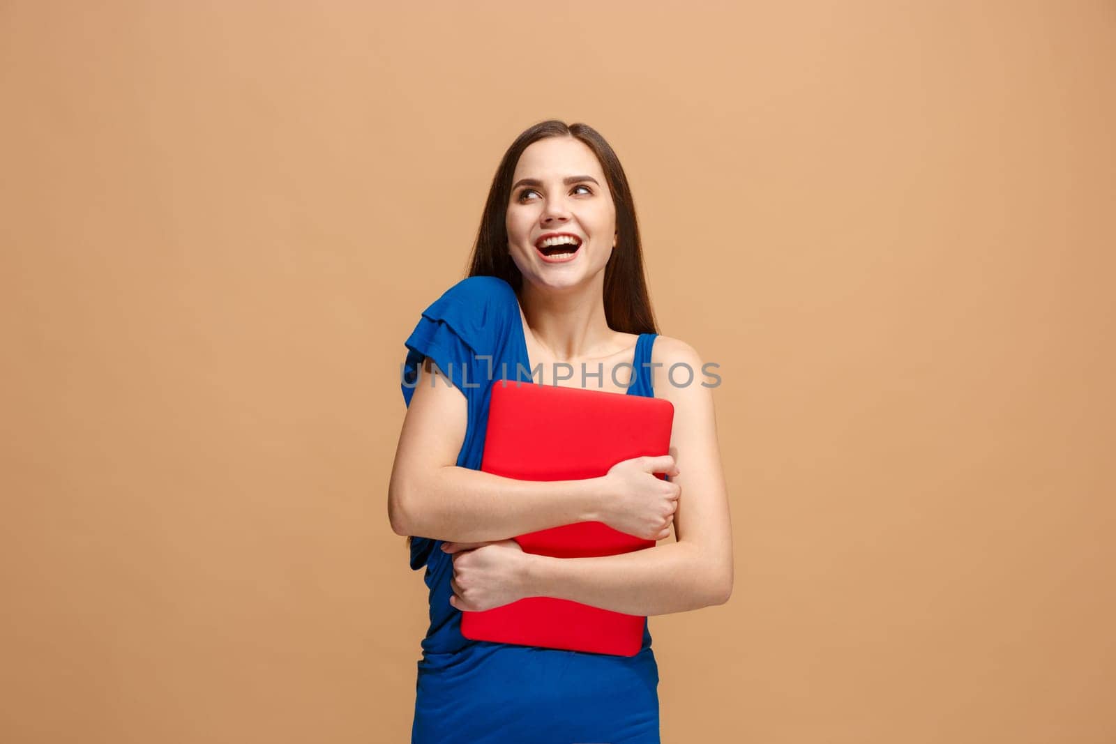 Businesswoman hugging laptop. Love to computer concept. Attractive female half-length front portrait, trendy pastel studio backgroud. Young emotional pretty woman. Human emotions, facial expression concept.