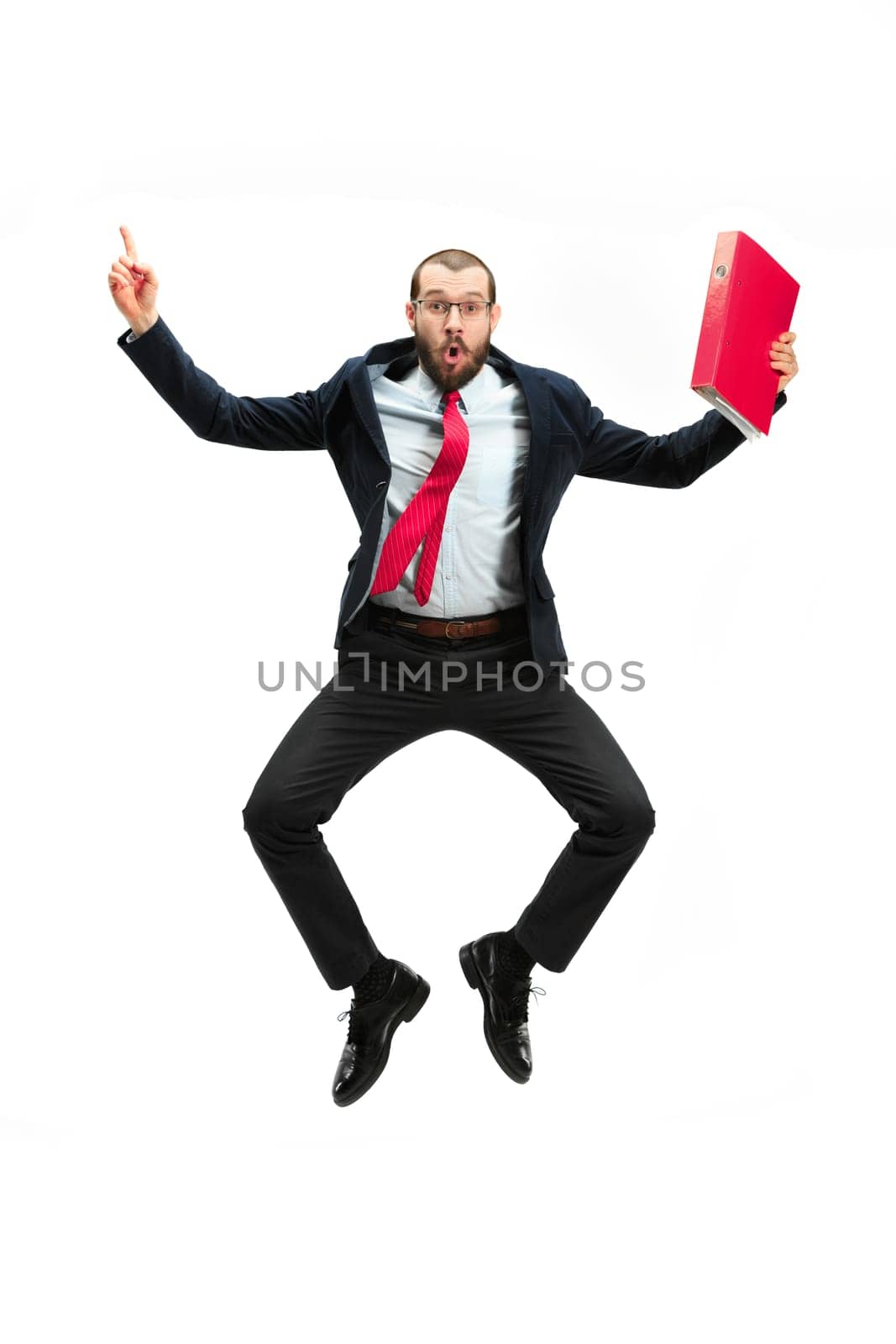 Funny cheerful businessman jumping in air over white studio background. Jump of happy bearded young man in glasses, suit. Business, career, success, win concept. Victory, delight concept. Human facial emotions
