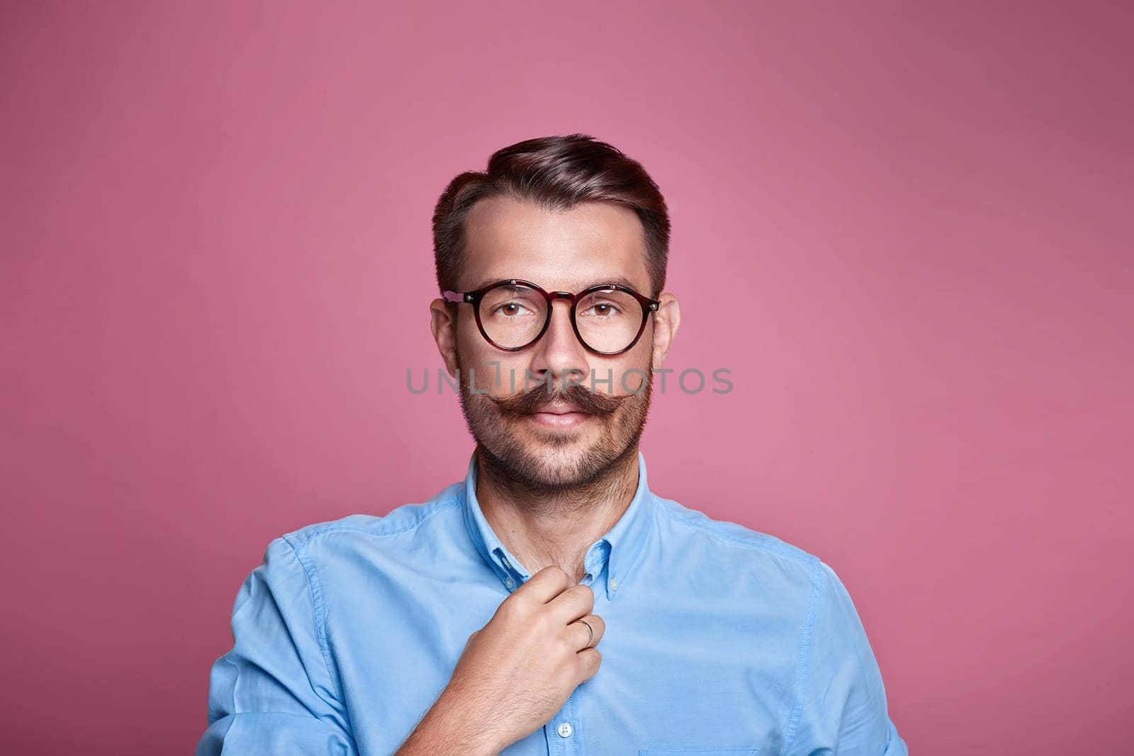 Portrait of a handsome young happy man over pink astudio background