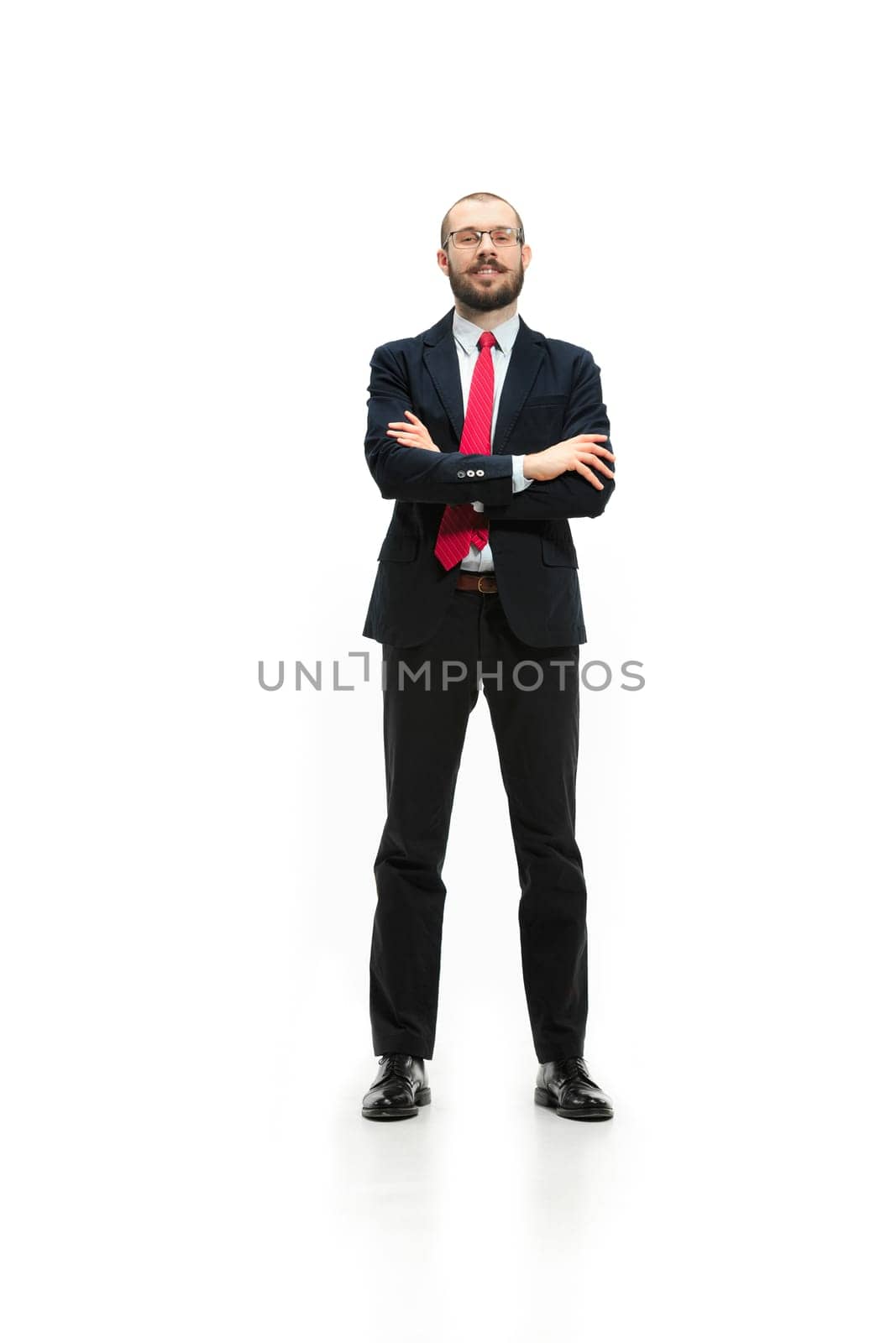 Full body or full-length portrait of businessman with red folder on white studio background. Serious bearded young man in glasses, suit, red tie standing in office. Business, career, success concept.