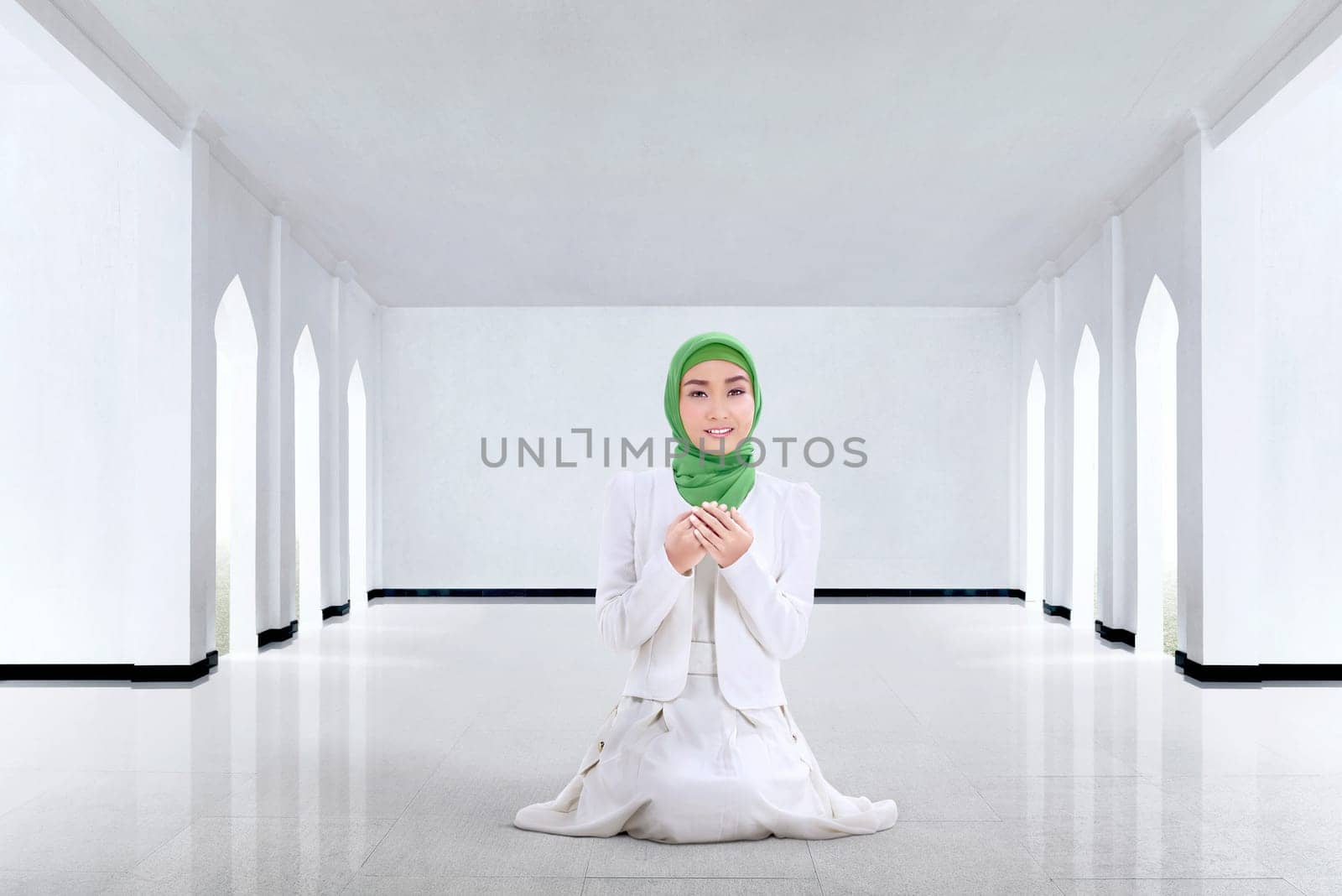 Pretty asian muslim woman praying to god in the mosque