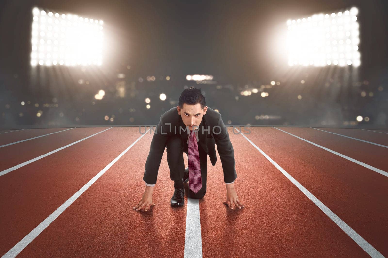 Young asian businessman ready for running with light on the background