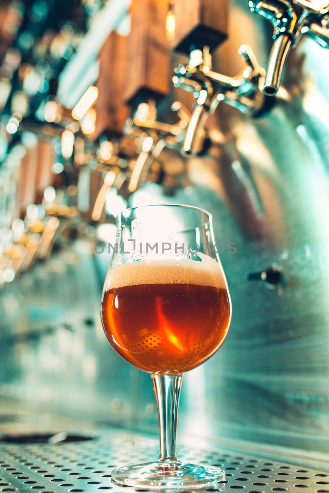 The beer taps in a pub. nobody. Selective focus. Alcohol concept. Vintage style. Beer craft. Bar table. Steel taps. Shiny taps. Glass of beer