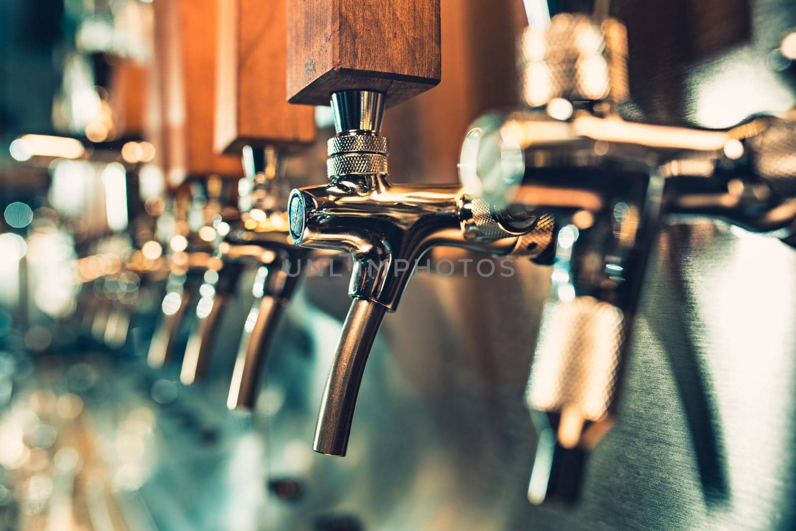 The beer taps in a pub. nobody. Selective focus. Alcohol concept. Vintage style. Beer craft. Bar table. Steel taps. Shiny taps.