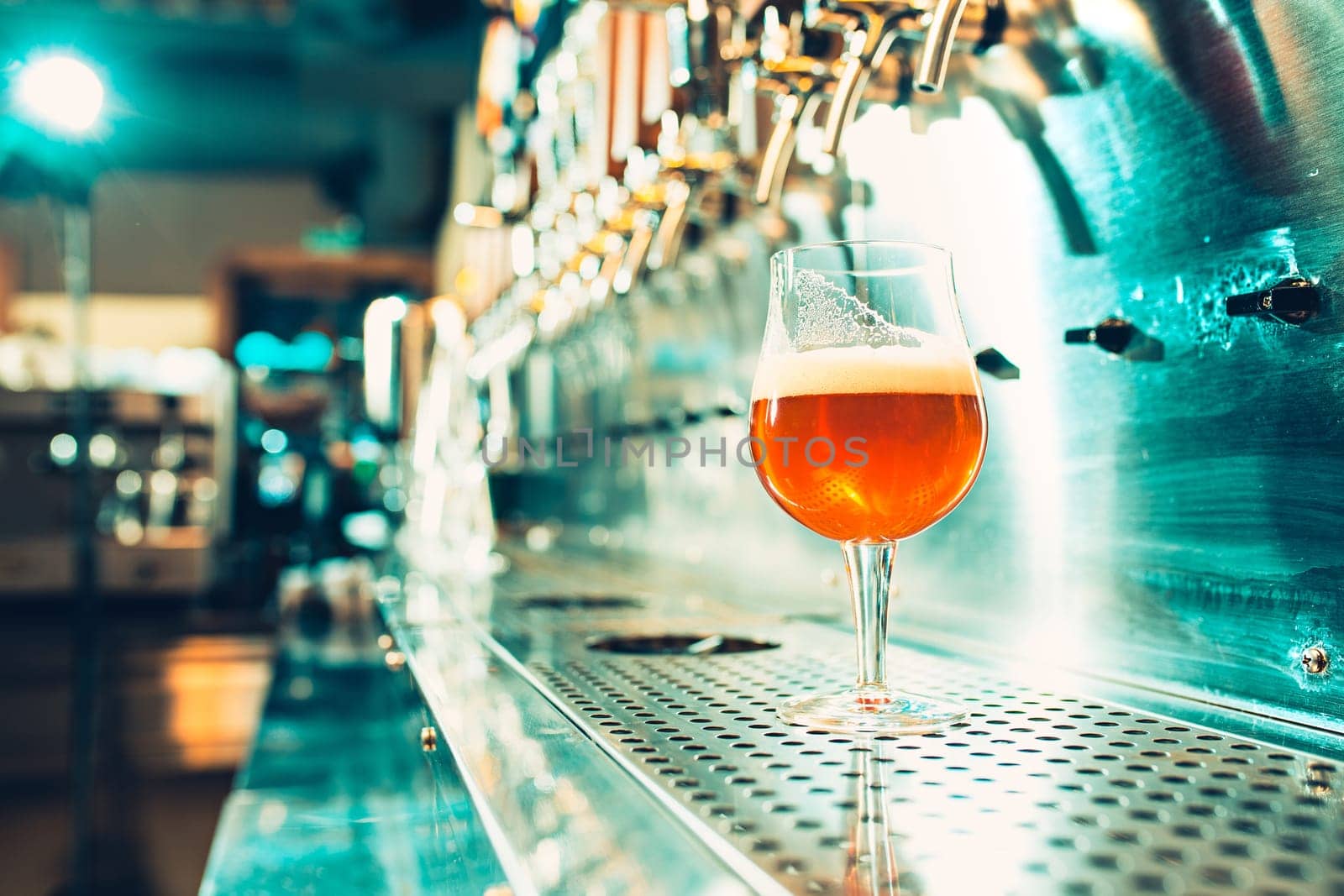 The beer taps in a pub. nobody. Selective focus. Alcohol concept. Vintage style. Beer craft. Bar table. Steel taps. Shiny taps. Glass of beer