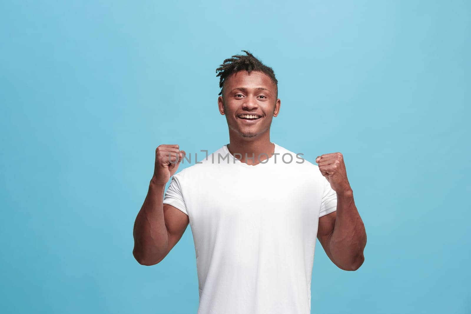 I won. Winning success happy afro man celebrating being a winner. Dynamic image of afro-american male model on blue studio background. Victory, delight concept. Human facial emotions concept. Trendy colors