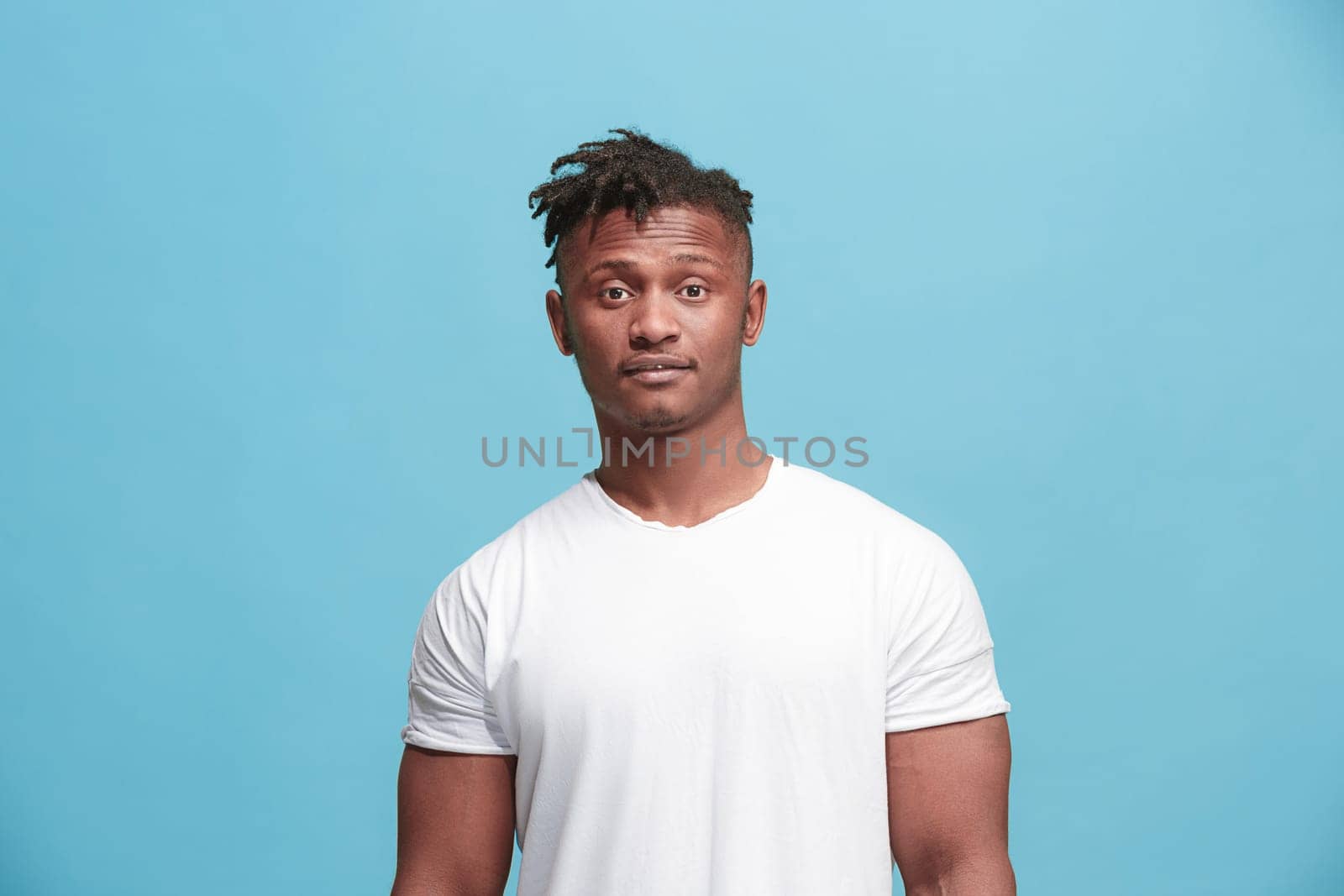 Delight. African american male half-length front portrait isolated on blue studio backgroud. Young, emotional, smiling, surprised man standing. Human emotions, facial expression concept. Trendy colors