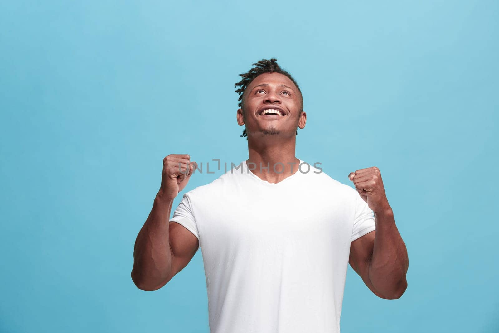 I won. Winning success happy afro man celebrating being a winner. Dynamic image of afro-american male model on blue studio background. Victory, delight concept. Human facial emotions concept. Trendy colors