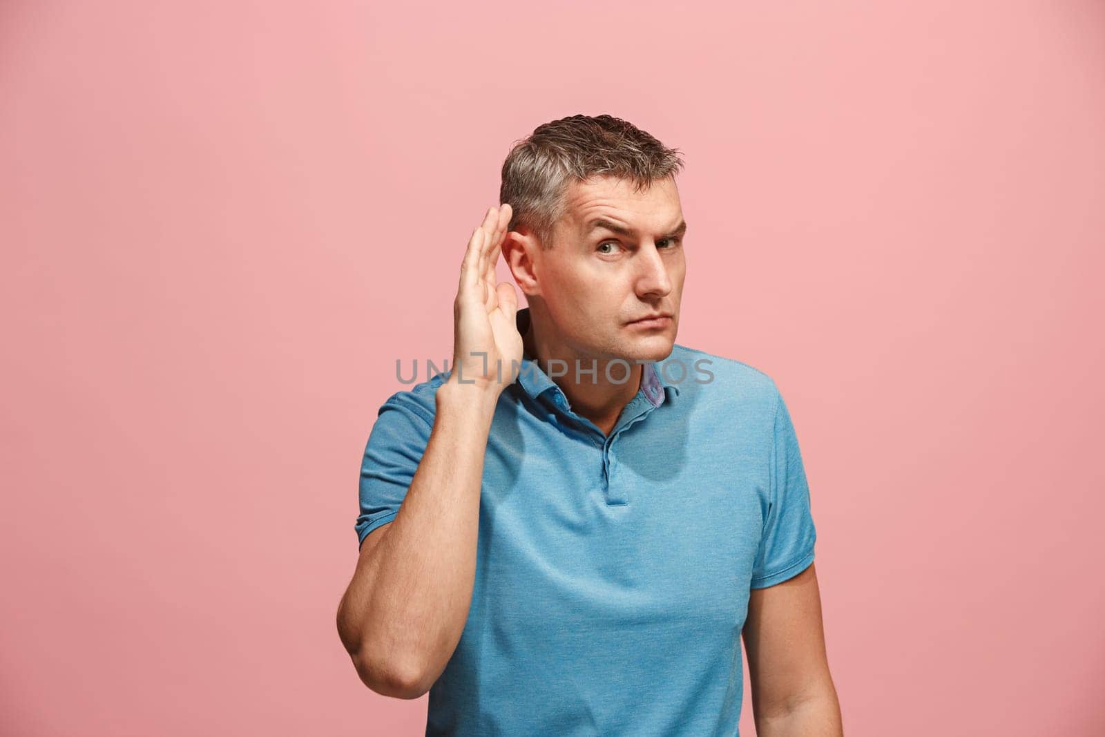 The happy business man standing and young man listening isolated on trendy pink studio background. Beautiful male half-length portrait. Young satisfy man. Human emotions, facial expression concept.