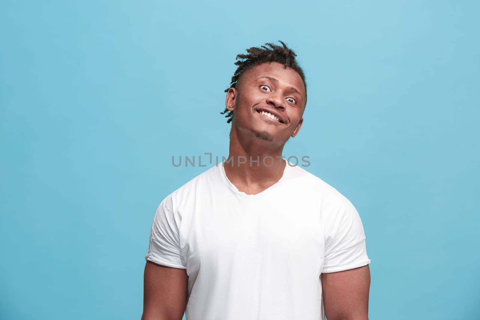 I lost my mind. The squint eyed man with weird expression. Beautiful male half-length portrait isolated on blue studio backgroud. The crazy man. The human emotions, facial expression concept.
