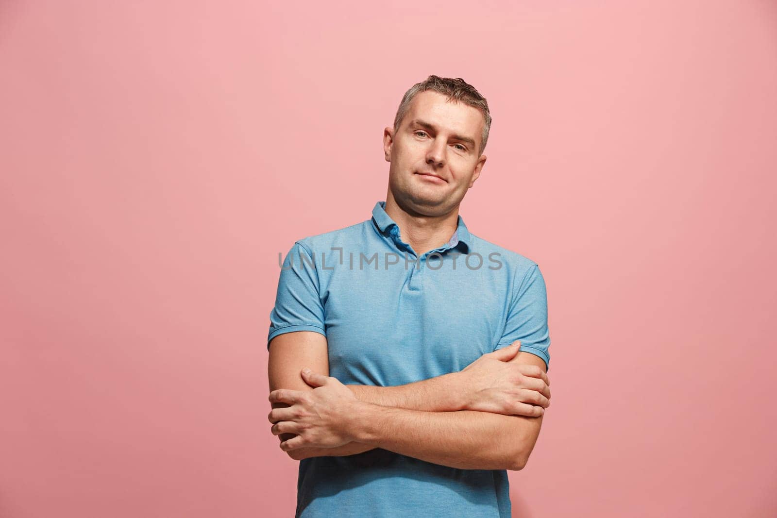 Happy business man standing and smiling isolated on pink studio background. Beautiful male half-length portrait. Young emotional man. The human emotions, facial expression concept. Front view.