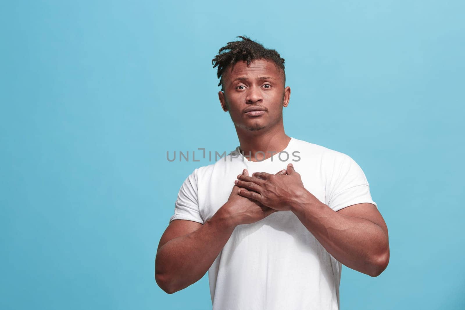 Happy business afro man standing and smiling isolated on blue studio background. Afro-american male half-length portrait. Young emotional man. The human emotions, facial expression concept. Front view.