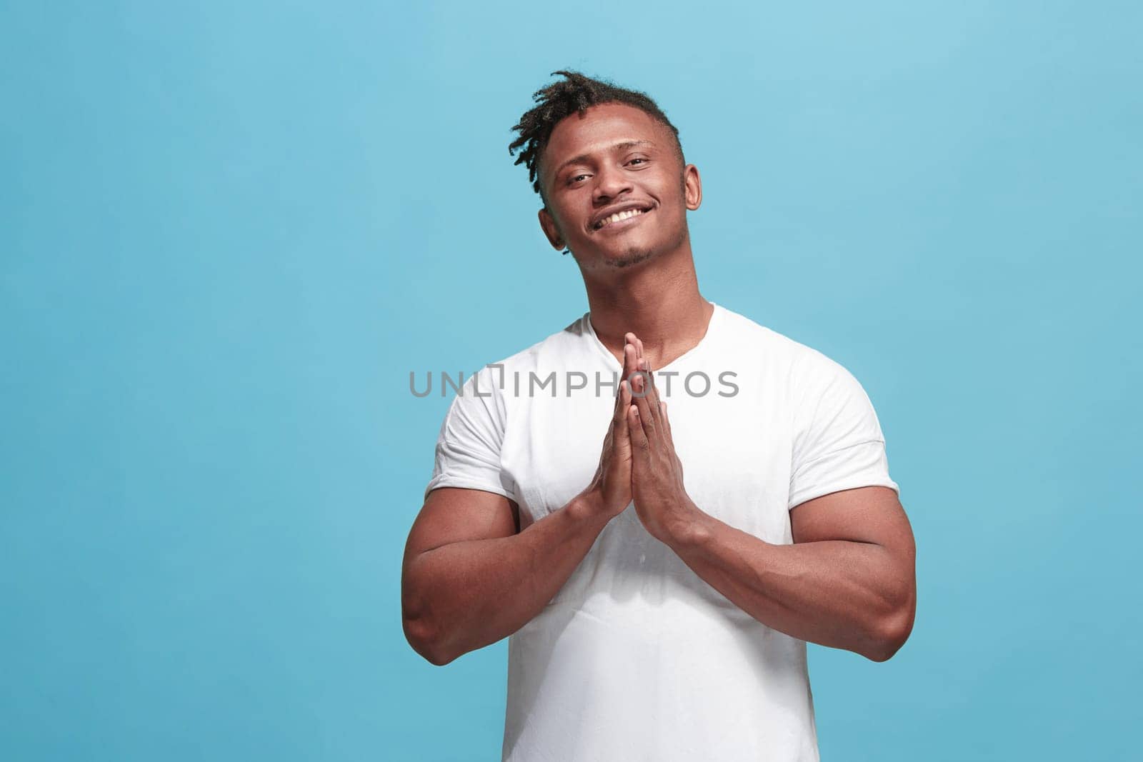 Happy business afro man standing and smiling isolated on blue studio background. Afro-american male half-length portrait. Young emotional man. The human emotions, facial expression concept. Front view.