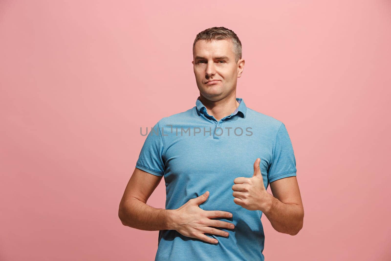 Happy business man standing and smiling isolated on pink studio background. Beautiful male half-length portrait. Young emotional man. The human emotions, facial expression concept. Front view.