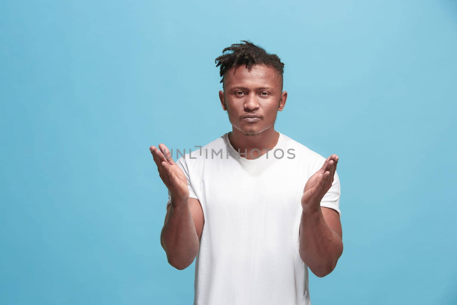 I kiss you. Portrait of attractive afro man with air kiss on lips. Blue studio. Beautiful male portrait. Young happy emotional funny man looking at camera. Human facial emotions concept. Trendy colors