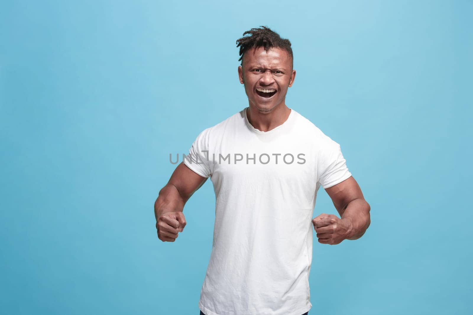 Screaming, hate, rage. Crying emotional angry afro man screaming on blue studio background. Emotional, young face. male half-length portrait. Human emotions, facial expression concept. Trendy colors