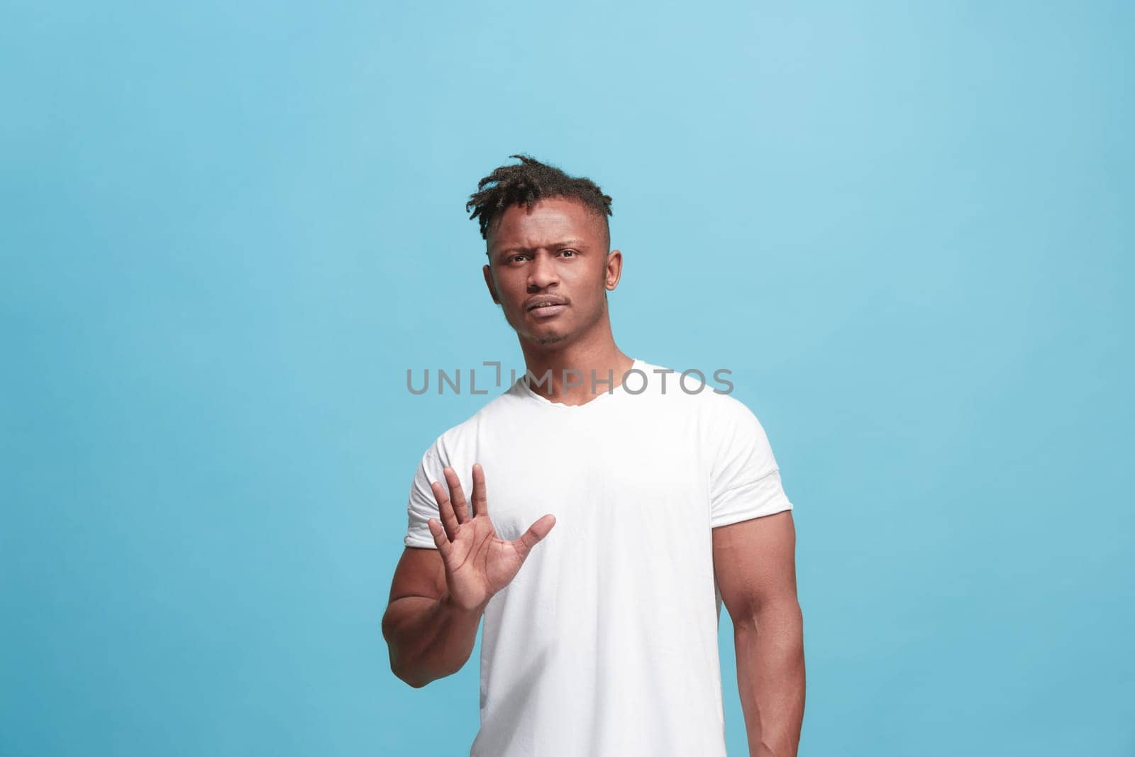Ew. It's so gross. Young afro man with disgusted expression repulsing something. Disgust concept. Young emotional man. Human emotions, facial expression concept. Studio. Isolated on trendy blue color