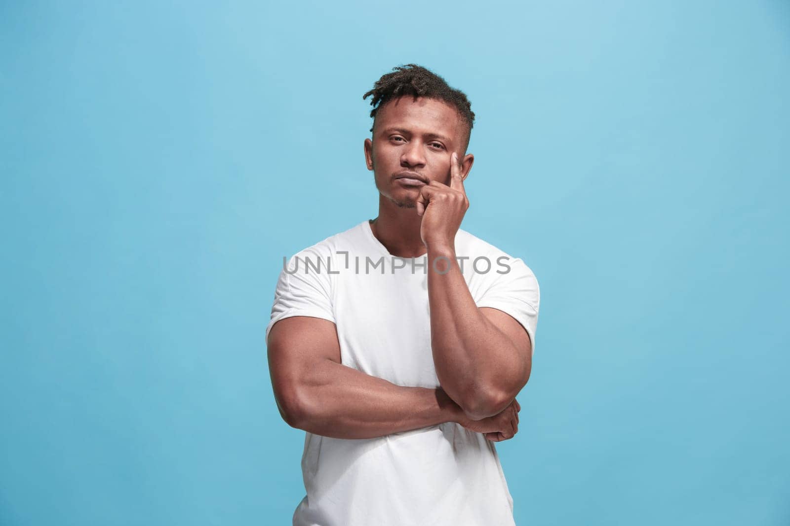 Remember all. Let me think. Doubt concept. Doubtful, thoughtful Afro-Fmerican man remembering something. Young emotional man. Human emotions, facial expression concept. Studio. Isolated on trendy blue