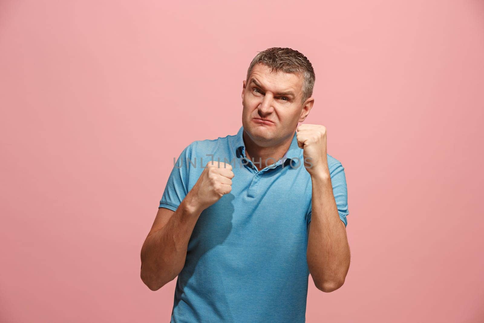 Screaming, hate, rage. Crying emotional angry man screaming on pink studio background. Emotional, young face. male half-length portrait. Human emotions, facial expression concept. Trendy colors