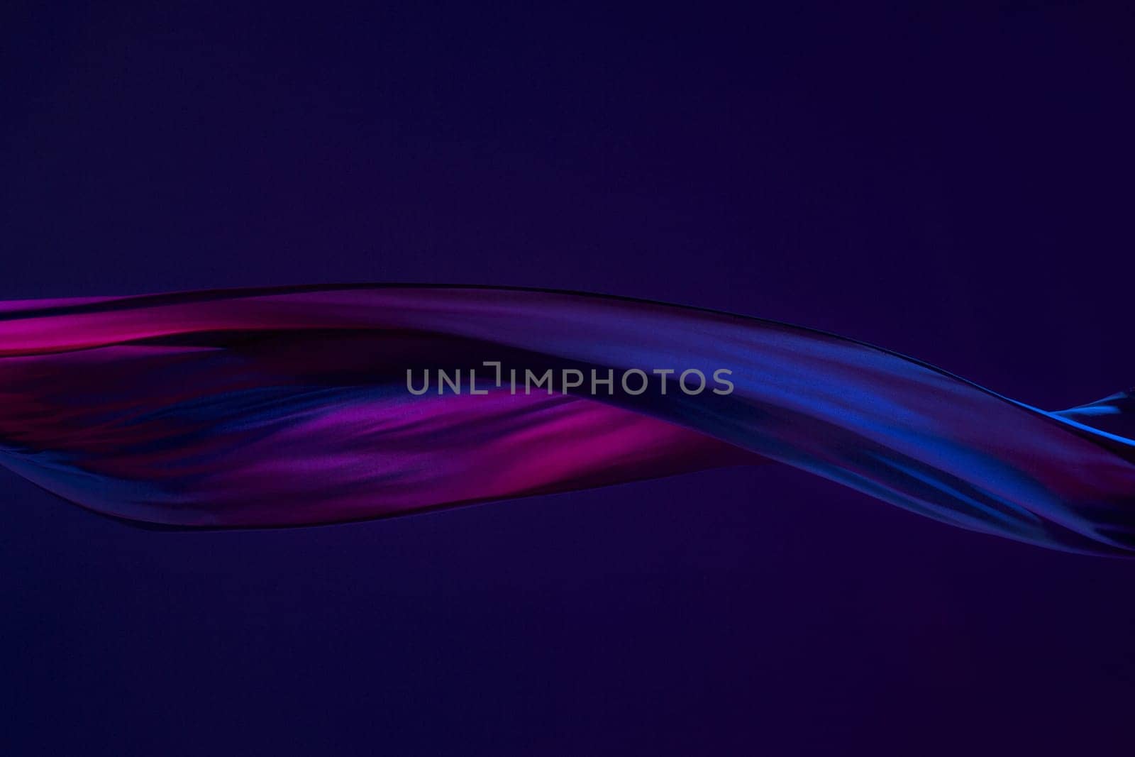 Smooth elegant transparent blue cloth isolated or separated on dark blue studio background. Texture of flying silk fabric.