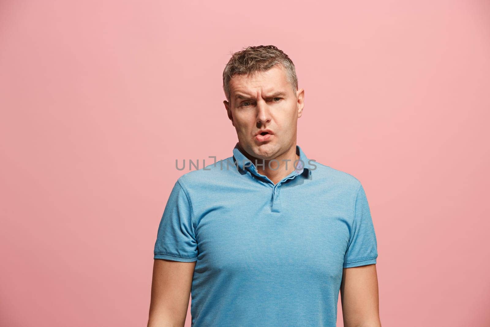 I am tired of everything. Bored man. Boring, dull, tedious concept. Young caucasian emotional man. Human emotions, facial expression concept. Studio Isolated on trendy pink background
