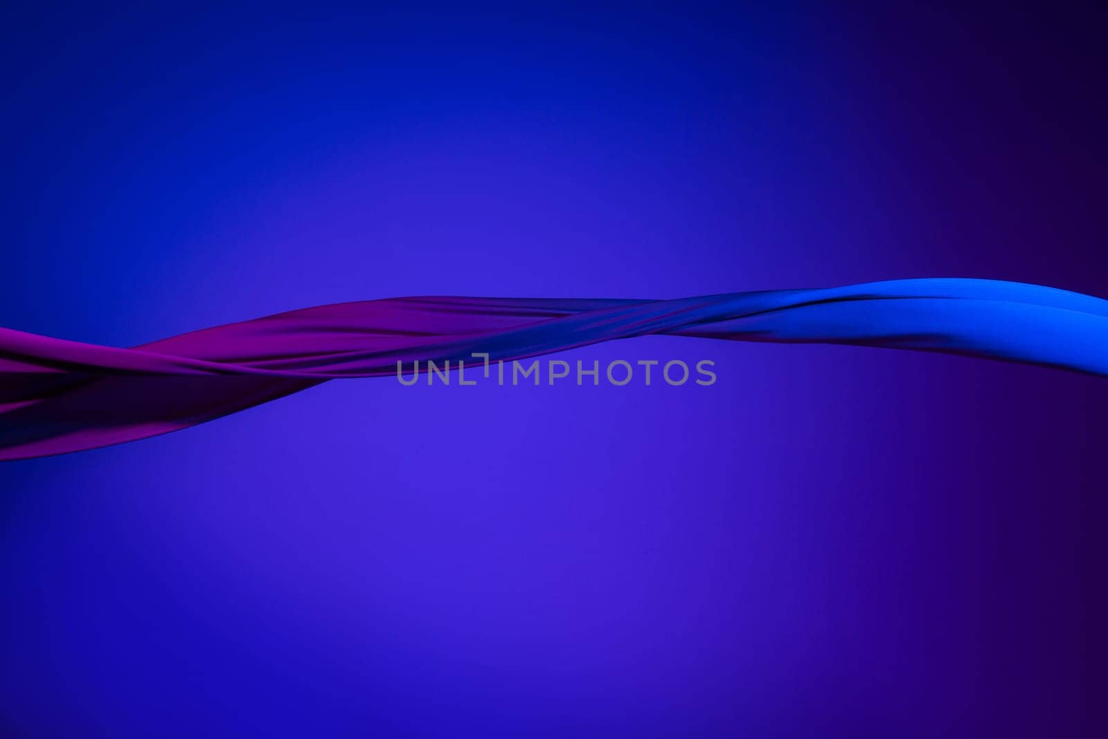 Smooth elegant transparent blue cloth isolated or separated on dark blue studio background. Texture of flying silk fabric.