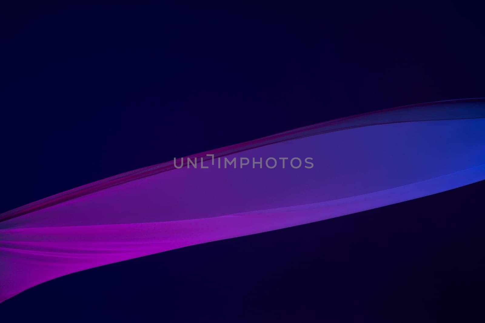 Smooth elegant transparent blue cloth isolated or separated on dark blue studio background. Texture of flying silk fabric.