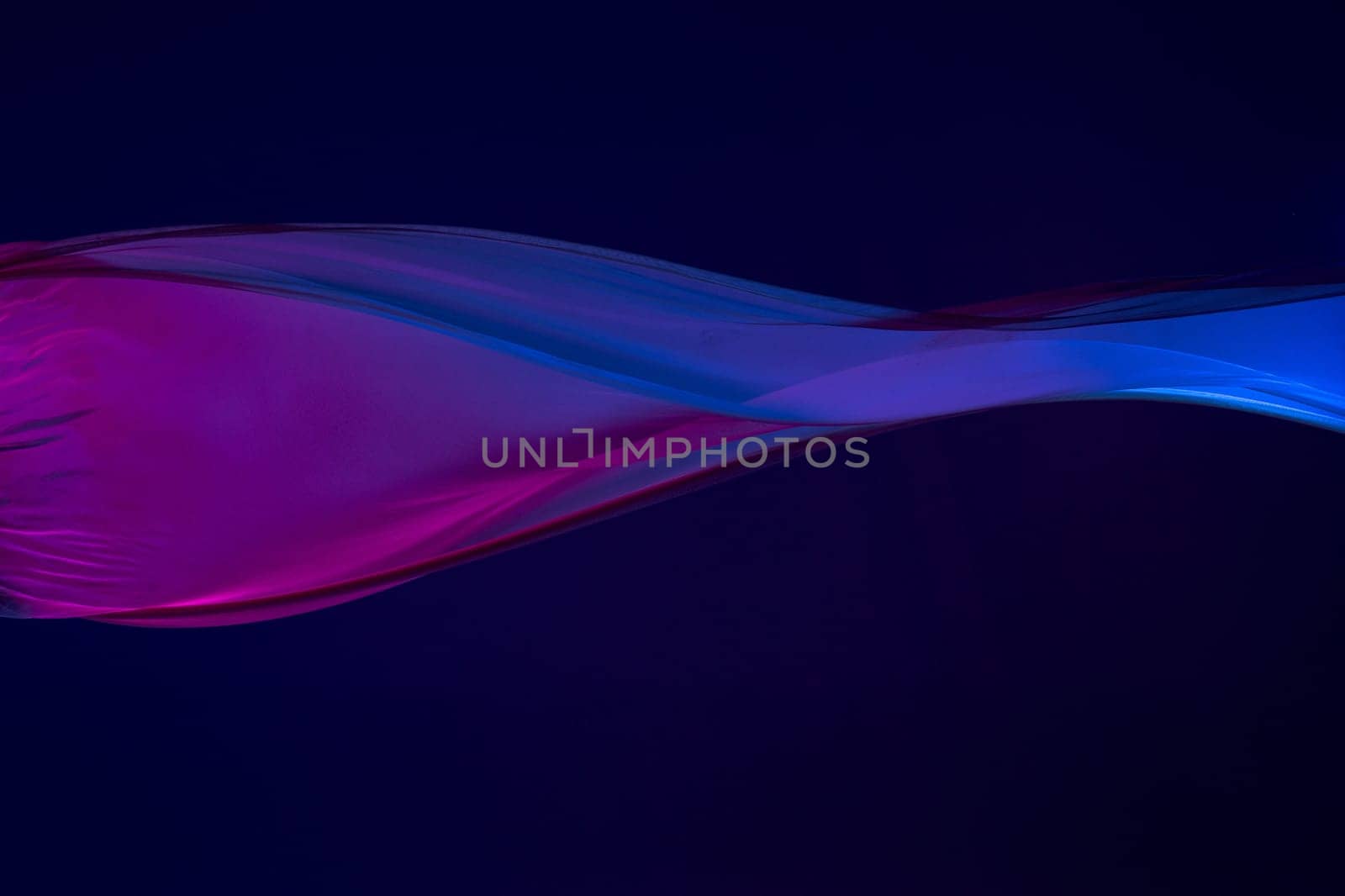 Smooth elegant transparent blue cloth isolated or separated on dark blue studio background. Texture of flying silk fabric.