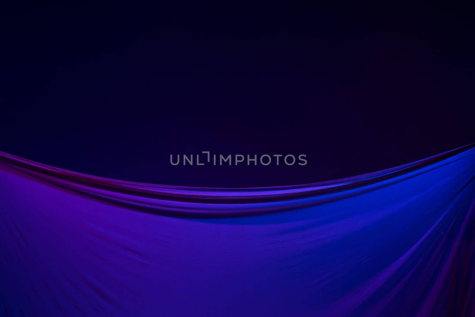 Smooth elegant transparent blue cloth isolated or separated on dark blue studio background. Texture of flying silk fabric.
