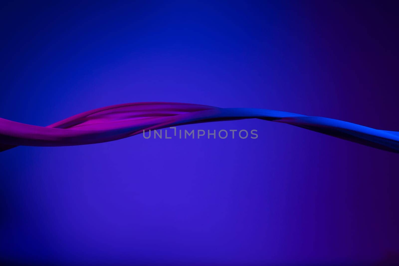 Smooth elegant transparent blue cloth isolated or separated on dark blue studio background. Texture of flying silk fabric.