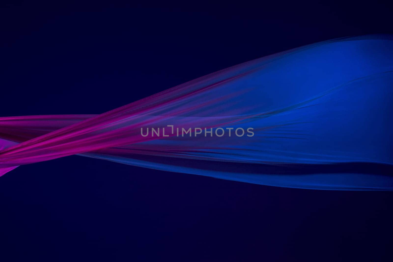 Smooth elegant transparent blue cloth isolated or separated on dark blue studio background. Texture of flying silk fabric.