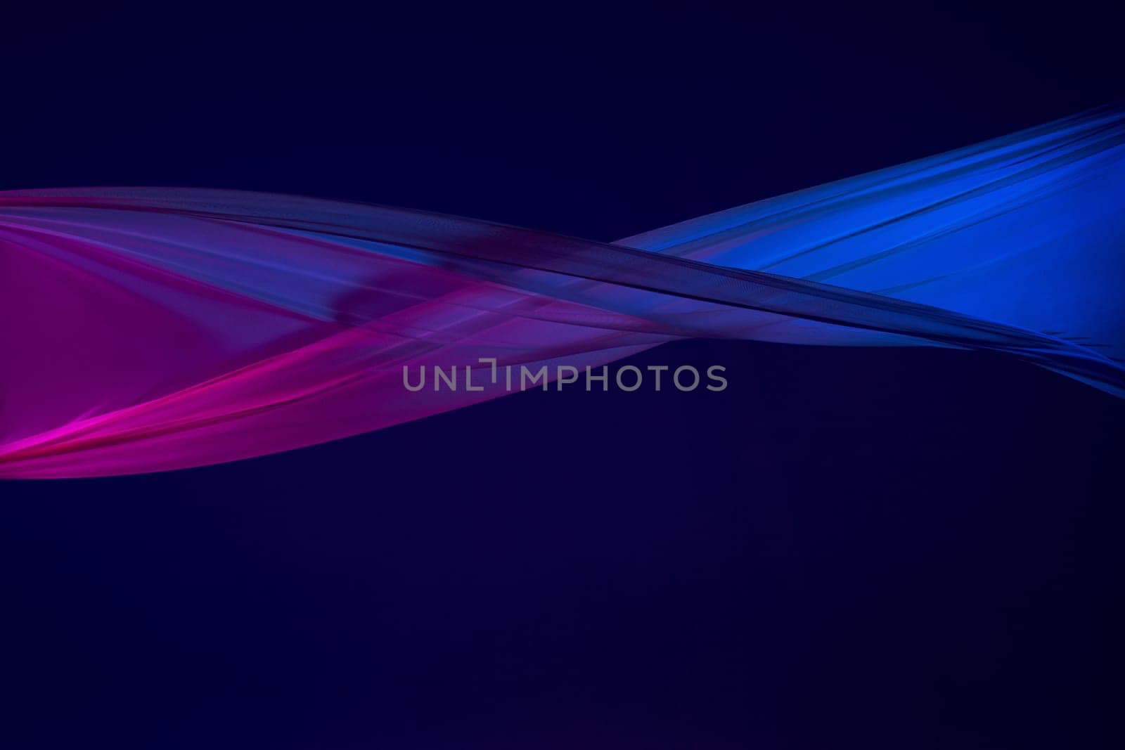 Smooth elegant transparent blue cloth isolated or separated on dark blue studio background. Texture of flying silk fabric.