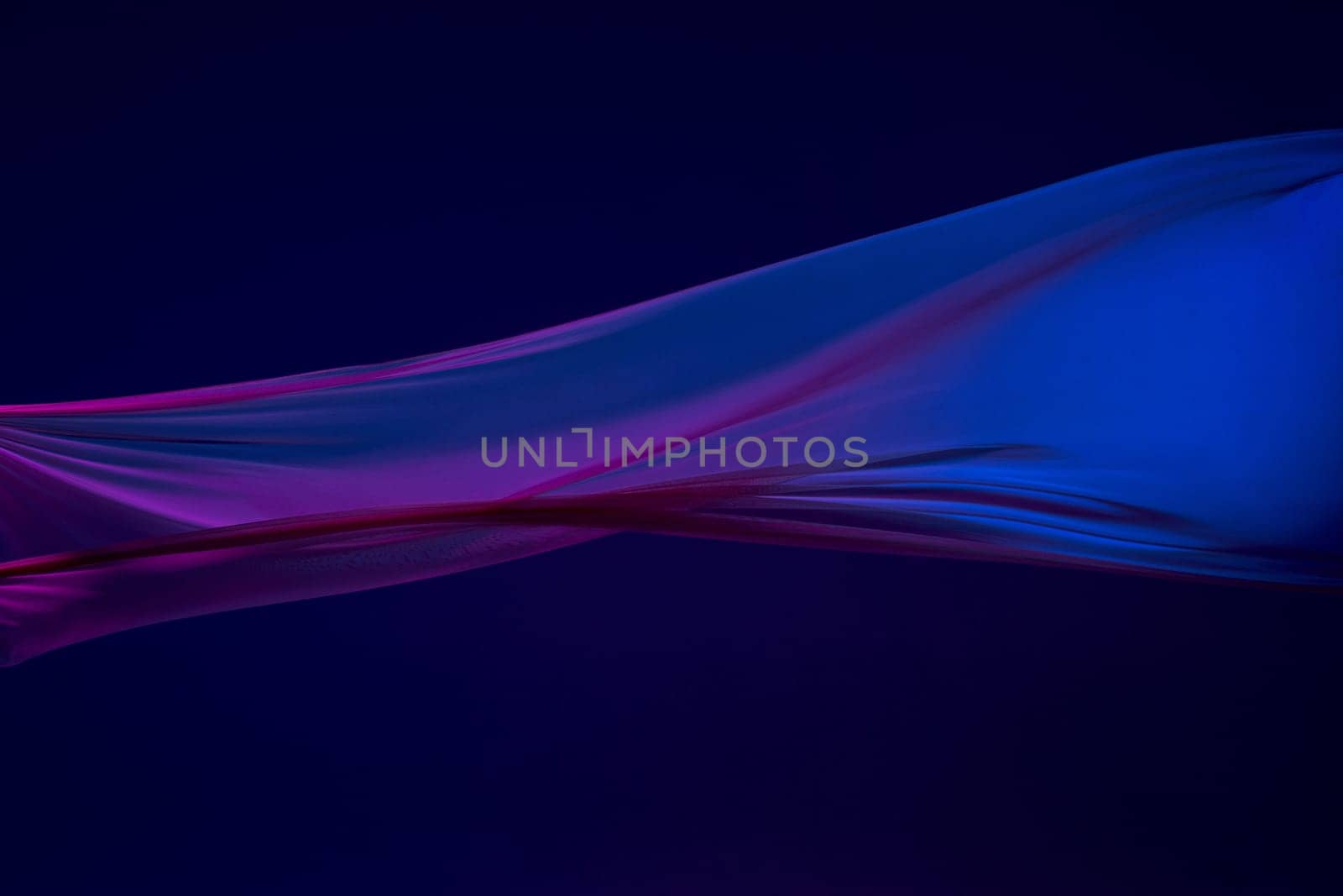 Smooth elegant transparent blue cloth isolated or separated on dark blue studio background. Texture of flying silk fabric.
