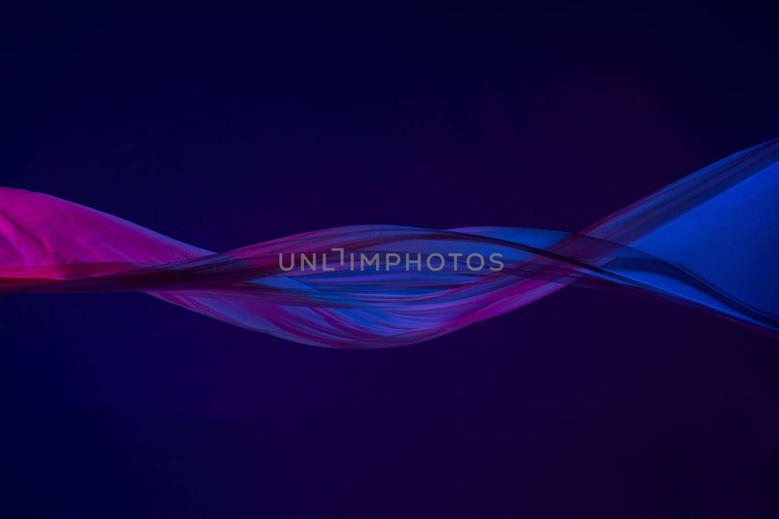 Smooth elegant transparent blue cloth isolated or separated on dark blue studio background. Texture of flying silk fabric.