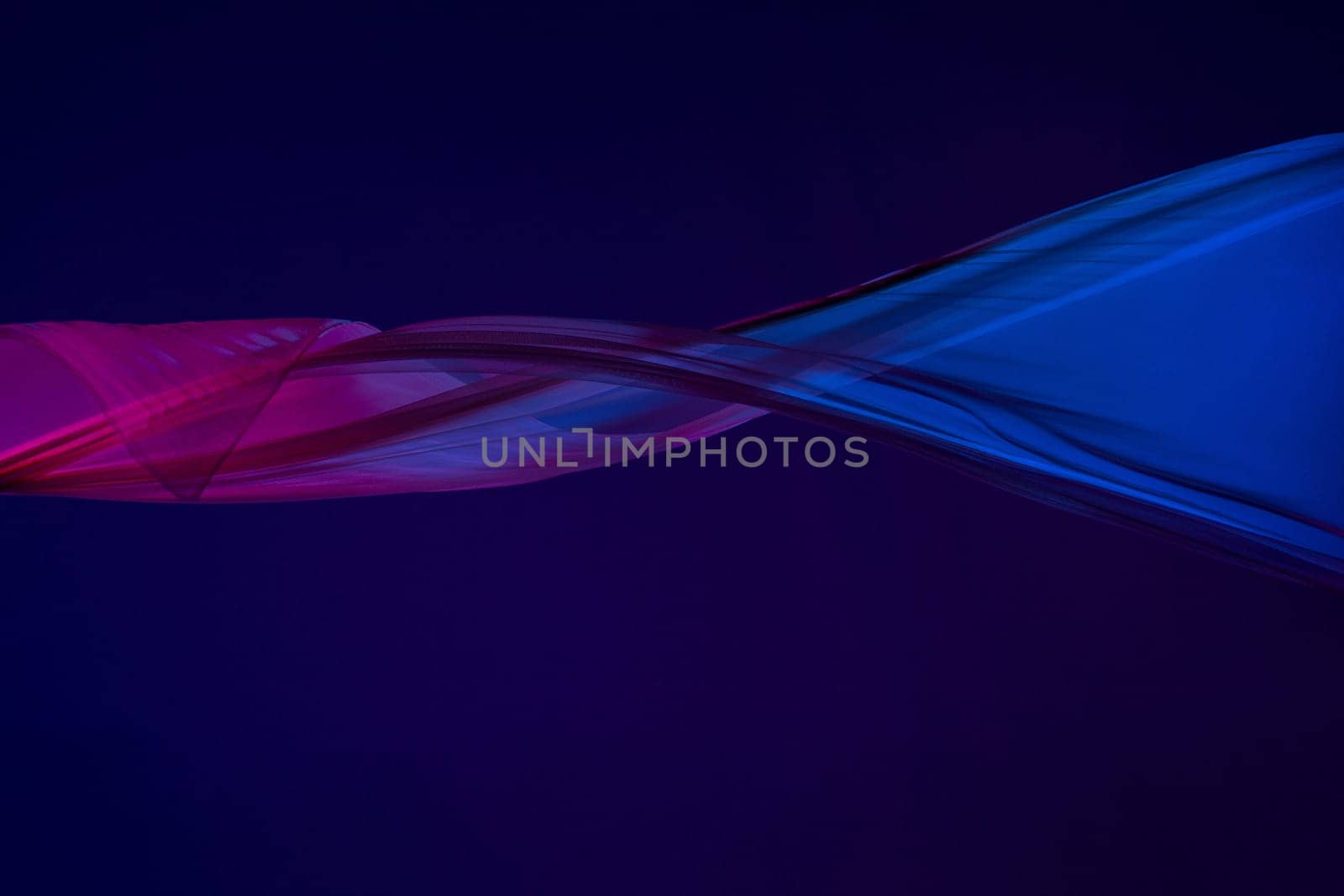Smooth elegant transparent blue cloth isolated or separated on dark blue studio background. Texture of flying silk fabric.