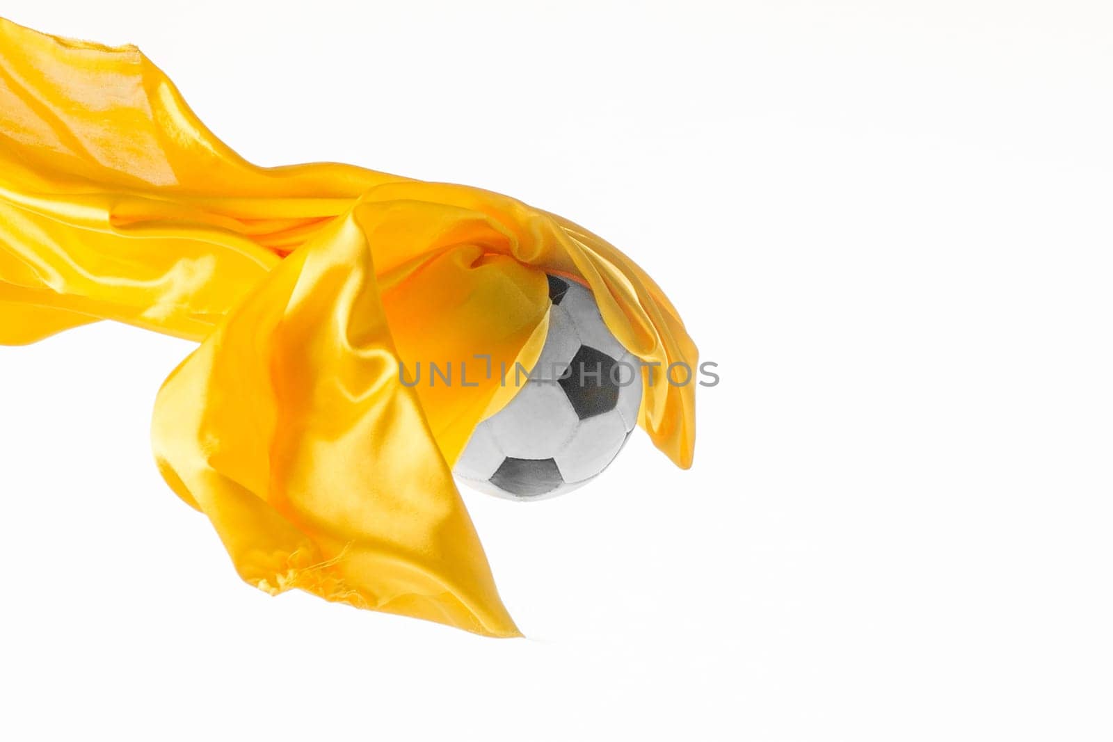 Soccer ball and Smooth elegant transparent yellow cloth isolated or separated on white studio background. Texture of flying fabric. yellow. Attributes of popular game. Concept of national flag color